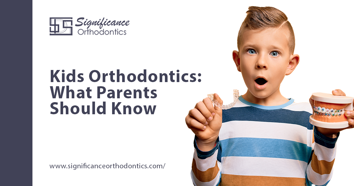 Boy holding clear aligner in one hand and mouth model with braces in the other as examples of kids orthodontics.